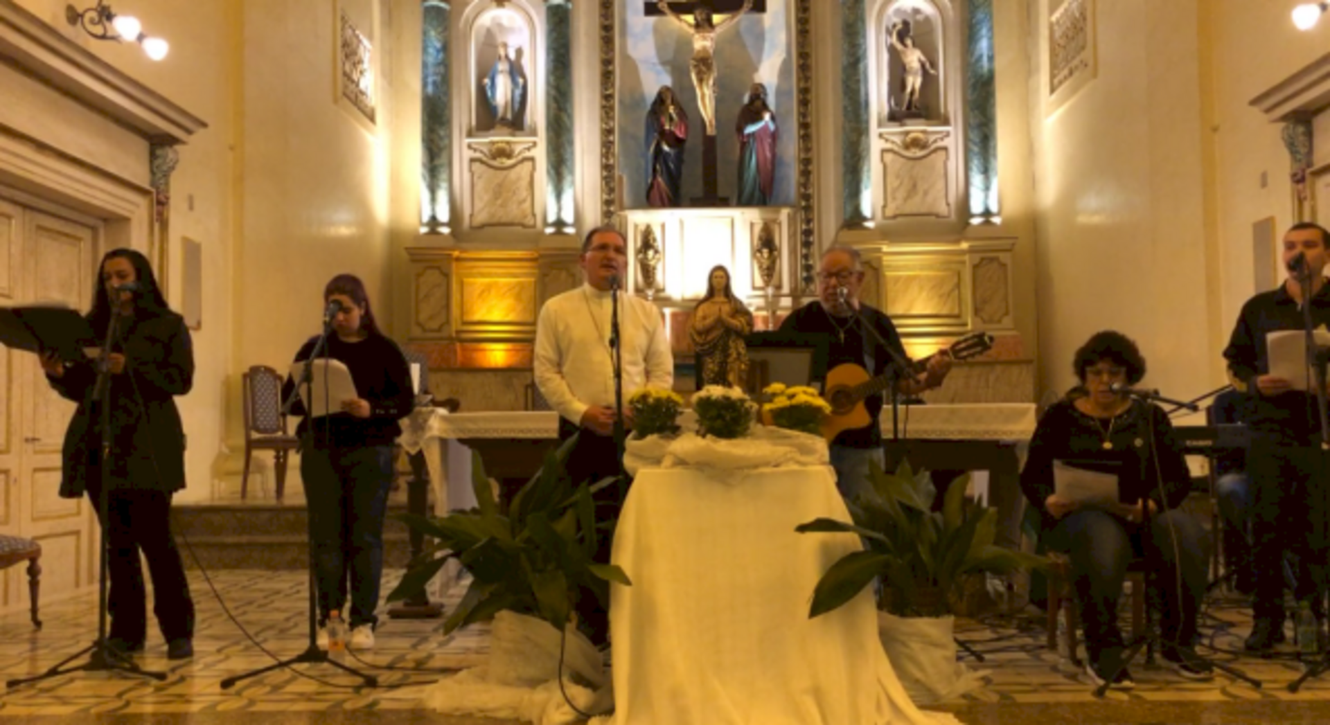 Bispo e grupo de cantores em louvor a Maria