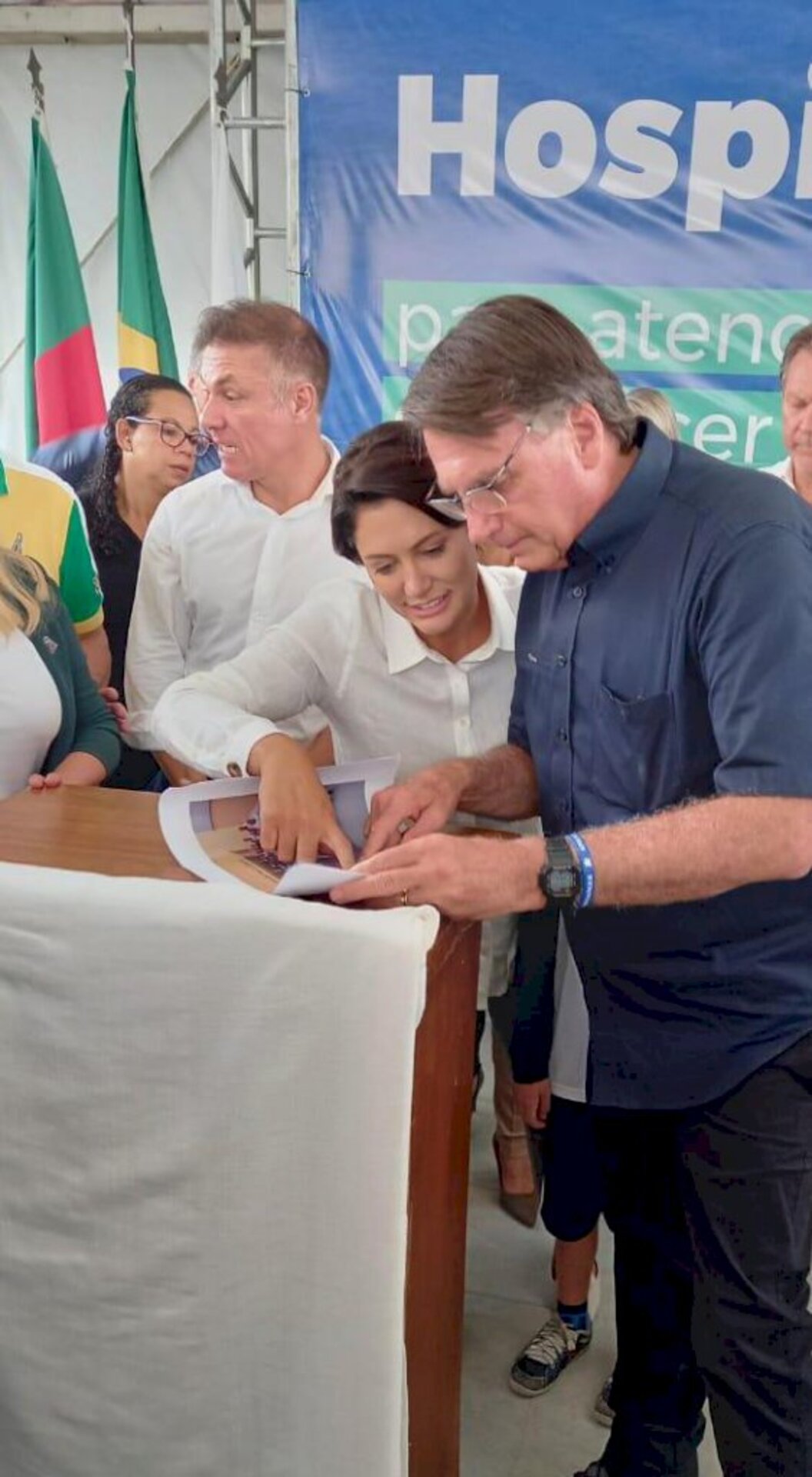 Michele e Bolsonaro olham atentos uma foto que ele recebeu, de quanto ainda estava na escola do Exército